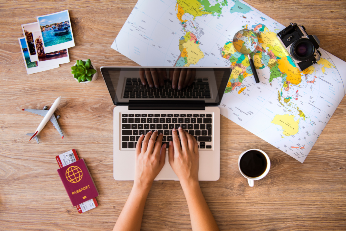 Mappa, computer, passaporto e accessori per organizzare un viaggio